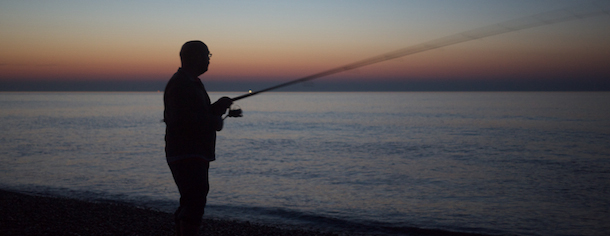 Fishing at sunset on Seaford beach, East Sussex.